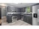 Modern kitchen with black cabinets, stainless steel appliances, and a stylish backsplash at 430 Pilgrim Ln, Powder Springs, GA 30127