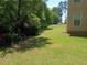 Lush backyard featuring a well-maintained lawn and shade trees at 5517 Rock Shoals Way, Atlanta, GA 30349