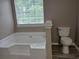 Bathroom featuring a large white tub and updated flooring at 5517 Rock Shoals Way, Atlanta, GA 30349