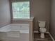 Bathroom featuring a large white tub and updated flooring at 5517 Rock Shoals Way, Atlanta, GA 30349