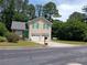 Charming two-story home with a well-manicured lawn, attached garage, and inviting green door at 5517 Rock Shoals Way, Atlanta, GA 30349