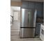 Modern kitchen with stainless steel refrigerator and gray cabinets adjacent to the stairs at 5517 Rock Shoals Way, Atlanta, GA 30349