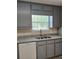 Updated kitchen featuring granite countertops, white subway tile backsplash, and stainless steel sink at 5517 Rock Shoals Way, Atlanta, GA 30349