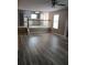 Open floorplan: living room with stairs, opening to the kitchen and beautiful wood-look floors at 5517 Rock Shoals Way, Atlanta, GA 30349