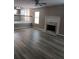 An open living room with stairs, a classic fireplace, and lovely wood-look floors at 5517 Rock Shoals Way, Atlanta, GA 30349