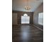 Bright living room with stylish gray wood floors, vaulted ceiling, and a charming chandelier at 5517 Rock Shoals Way, Atlanta, GA 30349