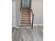 Classic staircase with light wood look flooring and trim, plus white risers and stringers at 5517 Rock Shoals Way, Atlanta, GA 30349