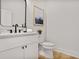Stylish half-bathroom featuring modern fixtures, a white vanity, and a decorative mirror at 73 Whitefoord Se Ave, Atlanta, GA 30317