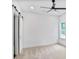 Bedroom with white carpet, large window, ceiling fan, and a sliding door at 73 Whitefoord Se Ave, Atlanta, GA 30317