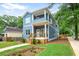 Charming two-story home featuring a covered porch, landscaped yard, and light blue siding at 73 Whitefoord Se Ave, Atlanta, GA 30317