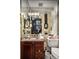 Stylish bathroom featuring a granite countertop, cherry wood vanity, and a well-organized walk-in closet at 1421 Peachtree Ne St # 203, Atlanta, GA 30309