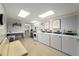 Bright laundry room with multiple washers and dryers, a folding table and a lounge area at 1421 Peachtree Ne St # 203, Atlanta, GA 30309