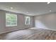 Spacious bedroom with new flooring, freshly painted walls, and a double window with wooded view at 1492 Harbins Rd, Norcross, GA 30093