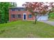 Charming two-story brick home with a well-manicured lawn and a two car garage at 1492 Harbins Rd, Norcross, GA 30093