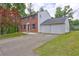 Side view of a brick home with a concrete driveway leading to a spacious two car garage at 1492 Harbins Rd, Norcross, GA 30093