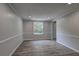 Neutral living room featuring new flooring, fresh paint and trim work, and large window at 1492 Harbins Rd, Norcross, GA 30093