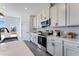 Contemporary kitchen featuring white cabinets, stainless steel appliances, and quartz countertops at 1713 Lansmere Sw St, Marietta, GA 30008