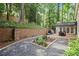 Spacious backyard featuring a brick retaining wall, patio, and gravel pathway at 3251 Pinestream Nw Rd, Atlanta, GA 30327
