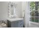 Bright bathroom with a gray vanity, decorative mirror and a view of the outdoors at 3251 Pinestream Nw Rd, Atlanta, GA 30327