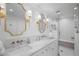 Bright bathroom featuring double sinks, marble countertops, gold fixtures and a glass enclosed shower at 3251 Pinestream Nw Rd, Atlanta, GA 30327