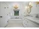 Elegant white bathroom with soaking tub, marble counters, and stylish gold light fixtures at 3251 Pinestream Nw Rd, Atlanta, GA 30327