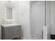 White subway tile shower with a glass enclosure and a gray vanity with decorative mirror frame at 3251 Pinestream Nw Rd, Atlanta, GA 30327