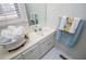 Bathroom features white vanity, floral towels, window for natural light, and white tile floors at 111 Dixson Rd, Bowdon, GA 30108
