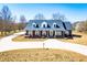 Beautiful brick home boasts a covered front porch, dormer windows, and a long, curved driveway at 111 Dixson Rd, Bowdon, GA 30108