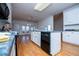 The kitchen has white cabinets, an island, a black dishwasher and hardwood floors at 111 Dixson Rd, Bowdon, GA 30108