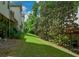 Backyard lawn area featuring mature tree and view of decks, fencing, and the rear of the townhomes at 3692 Lambert Ne Ln, Brookhaven, GA 30319