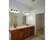 Bathroom with double sinks, wood cabinets, large mirror and doorway to closet at 3692 Lambert Ne Ln, Brookhaven, GA 30319
