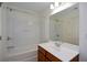 This clean, bright bathroom features a tub, shower combo and a vanity with a white countertop and wood cabinetry at 3692 Lambert Ne Ln, Brookhaven, GA 30319