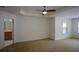 Spacious bedroom with neutral carpet, ceiling fan, and access to the bathroom, offering a relaxing retreat at 3692 Lambert Ne Ln, Brookhaven, GA 30319