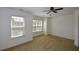 A light-filled carpeted bedroom features neutral walls and a ceiling fan and two large windows bringing in natural light at 3692 Lambert Ne Ln, Brookhaven, GA 30319