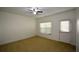 This carpeted bedroom boasts a ceiling fan and natural light, with access to the outside from a door on the right at 3692 Lambert Ne Ln, Brookhaven, GA 30319
