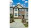 Traditional brick townhome with two car garage, covered porch, and steps leading to front door at 3692 Lambert Ne Ln, Brookhaven, GA 30319