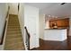 Hallway featuring carpeted stairs with a wooden handrail and access to the kitchen at 3692 Lambert Ne Ln, Brookhaven, GA 30319