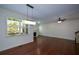 Cozy living room with hardwood floors, a fireplace, a ceiling fan, and large window views at 3692 Lambert Ne Ln, Brookhaven, GA 30319