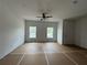 A basic, unfinished living room with two large windows and ceiling fan at 5108 Arista Dr, Douglasville, GA 30135