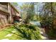 Private backyard features a covered pool, stone pathway, lush greenery, and a patio area at 9995 Huntcliff Trce, Atlanta, GA 30350