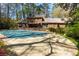Spacious backyard with covered pool area, lush landscaping, and brick patio at 9995 Huntcliff Trce, Atlanta, GA 30350
