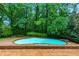 Backyard swimming pool surrounded by mature trees offering a private retreat with natural beauty at 9995 Huntcliff Trce, Atlanta, GA 30350