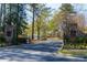 Landscaped entrance to Cherokee Country Club with stone columns and wrought iron gating at 9995 Huntcliff Trce, Atlanta, GA 30350