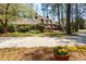 Inviting front exterior showing manicured lawn, blossoming flowers, and a circular driveway at 9995 Huntcliff Trce, Atlanta, GA 30350