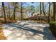 Long, private driveway and picturesque view of the stately home nestled among mature trees at 9995 Huntcliff Trce, Atlanta, GA 30350