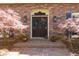 Elegant front entrance featuring decorative glass doors, potted plants and mature trees at 9995 Huntcliff Trce, Atlanta, GA 30350
