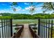 Scenic lake view from a private dock with seating, surrounded by lush greenery and clear skies at 9995 Huntcliff Trce, Atlanta, GA 30350