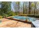 Landscaped backyard featuring a covered pool area with flower beds, perfect for a tranquil retreat at 9995 Huntcliff Trce, Atlanta, GA 30350