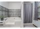 Bright bathroom featuring a shower and tub combo with decorative tile and plant at 1888 Kelvin Dr, Lawrenceville, GA 30043