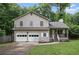 Charming two-story home with a two-car garage and inviting front porch nestled amongst the trees at 1888 Kelvin Dr, Lawrenceville, GA 30043